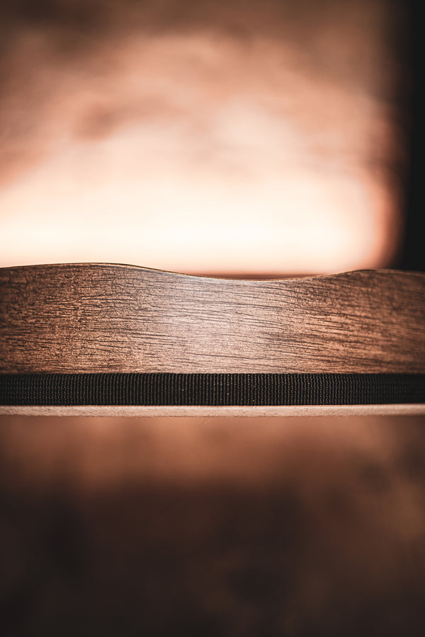 A close up of a Meinl 18" Woven Synthetic Head Hand Drum on a wooden table with a blurred background.