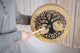 A man holding a gong with a Meinl 15" Native American-Style Hoop Drum, featuring the Tree of Life on it.