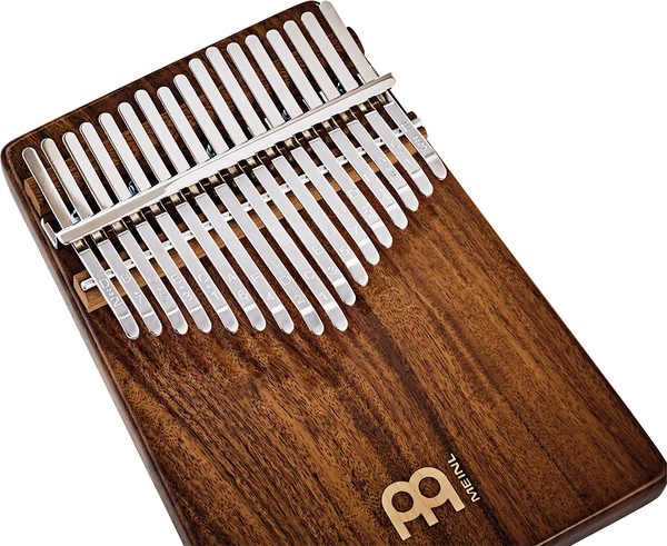 A melodic instrument made of Meinl 17 notes Kalimba, Acacia wood, resembling a wooden xylophone, placed on a white background.