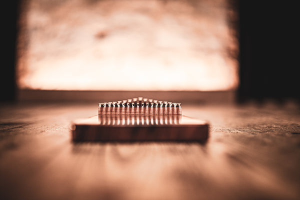 A Meinl 17 notes Kalimba, Acacia wood comb sitting on top of a wooden table.