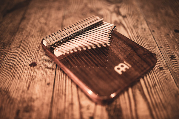 A 21 notes Kalimba, Black Walnut by Meinl on a wooden table.