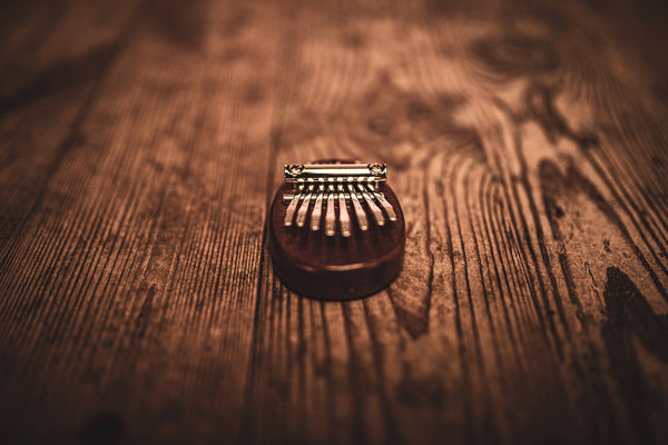 A Meinl 8 notes Kalimba, made of sapele wood, placed on a wooden table.