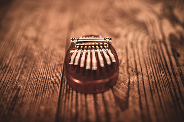 A Meinl 8 notes Kalimba, made of sapele wood, resting on a wooden table.