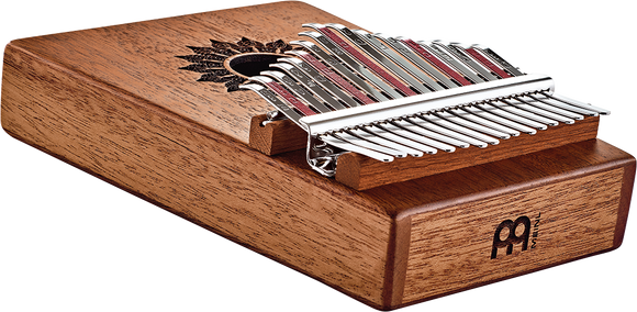 A wooden box with a Meinl 17 notes Kalimba, Mahogany, a musical instrument inside.