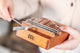 A person is holding a Meinl 17 notes Kalimba, Mahogany, a wooden instrument used in sound healing therapy.