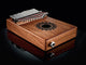 A Meinl 17 notes Kalimba, Mahogany instrument on a black surface.